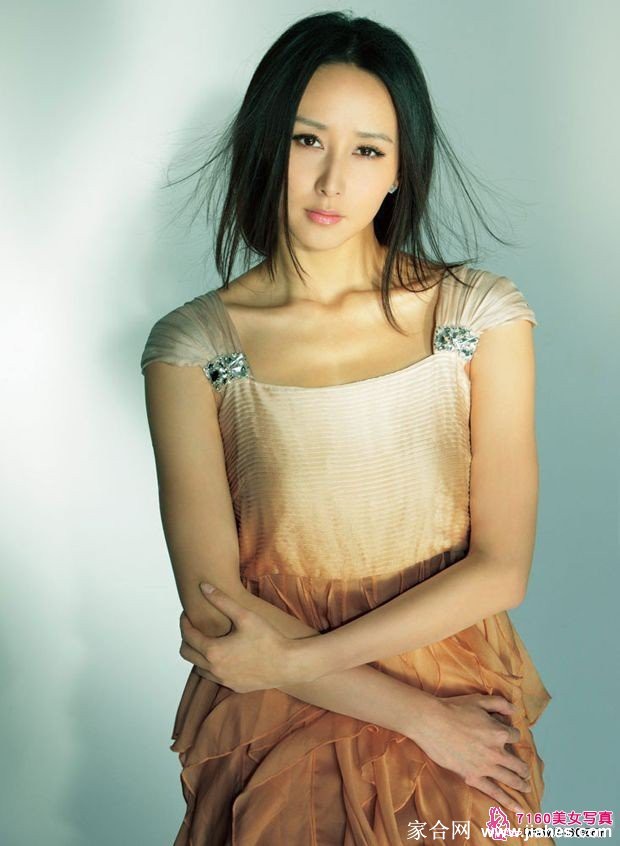 胡静身着简约服饰倚靠窗边，柔和日光勾勒出恬静优雅的侧影