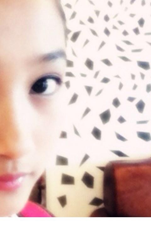 关晓彤身着白裙坐在白色雕花长椅上托腮远眺，流露出一丝俏皮与纯真