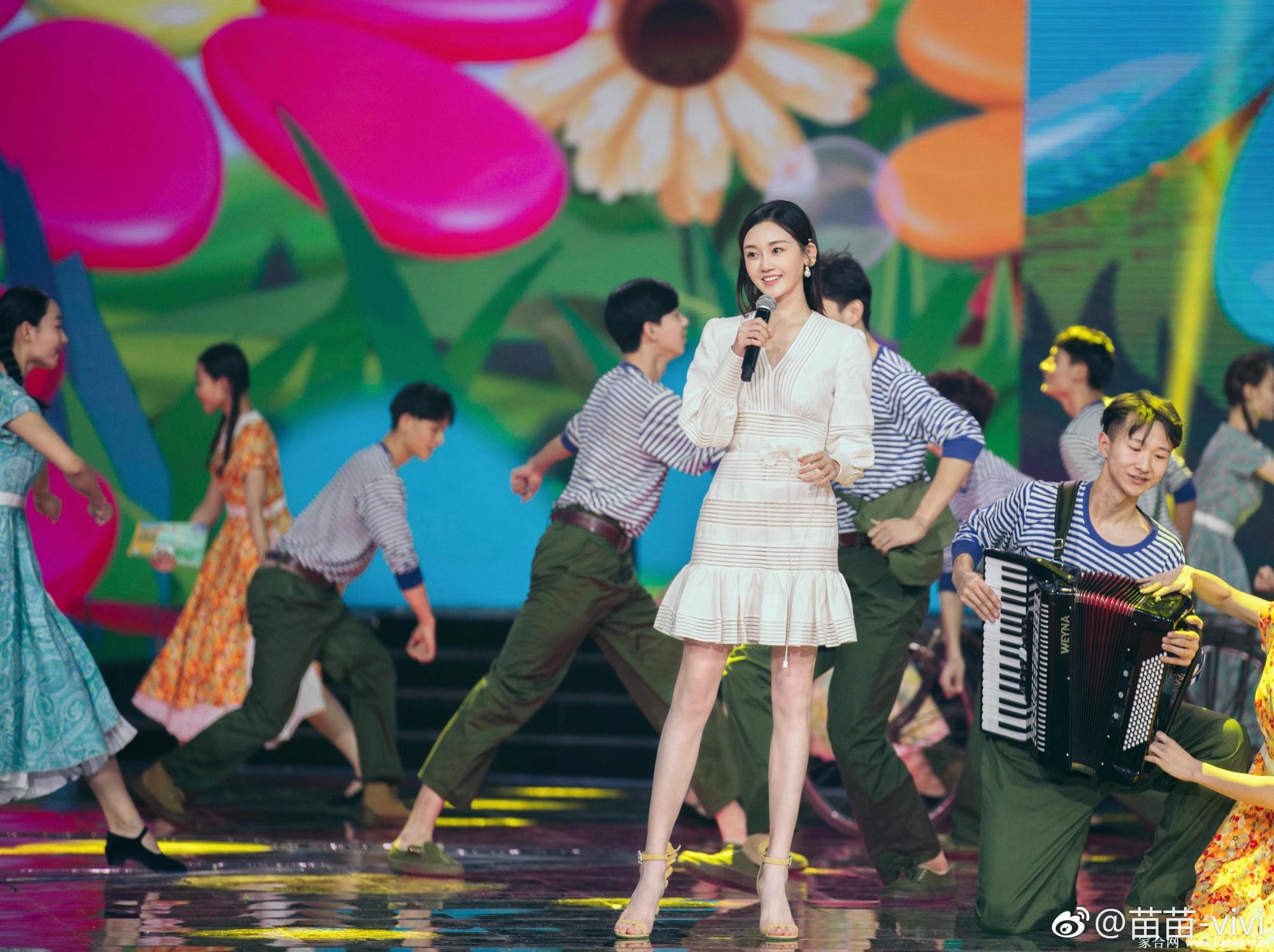 苗苗坐姿端庄，高跟鞋尖轻点地面，网纱裙摆下隐约透出丝袜的细腻纹理