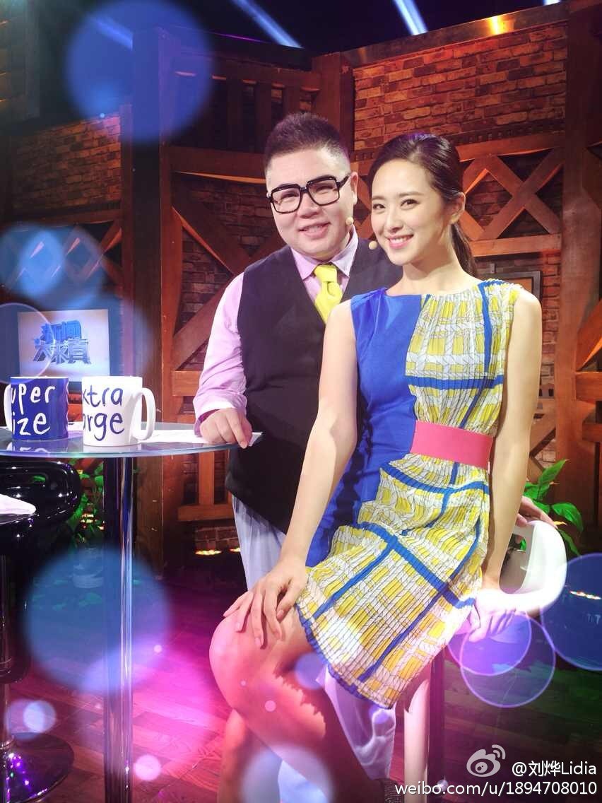 刘烨在后台与工作人员交流，精致妆容与时尚穿搭尽显幕后风采