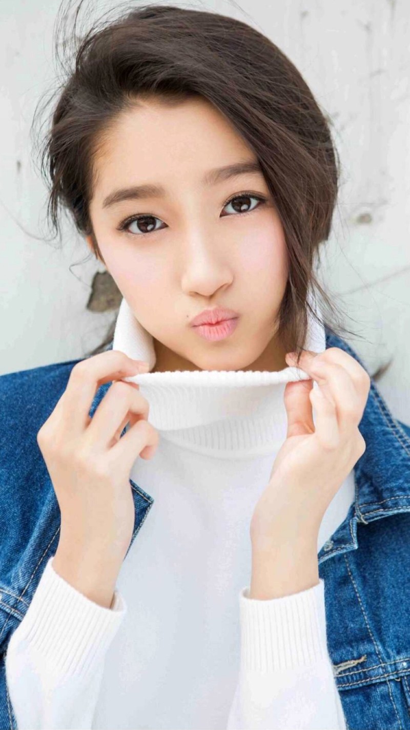 关晓彤身着白裙置身花园，手抚秀发对镜头俏皮嘟嘴，眼神灵动如夏日精灵