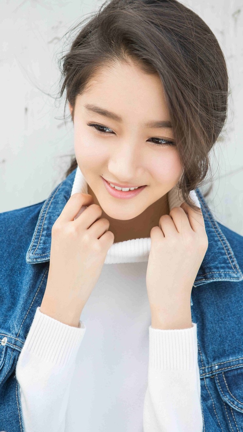 关晓彤赤足漫步于葱郁草地，回眸浅笑发丝随风轻扬，尽显清新灵动气质