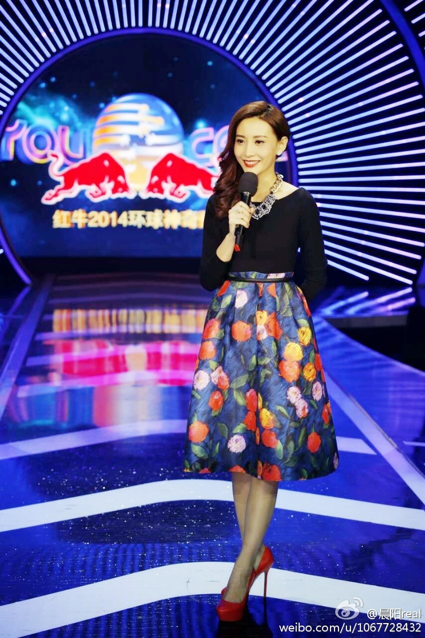 晨阳手持台本微侧脸庞，聚光灯下神情专注，黑色高跟鞋勾勒出专业姿态