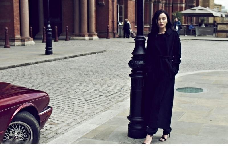 宋佳侧身而立，黑色呢绒风衣与内搭长裙勾勒出优雅修长的 silhouette