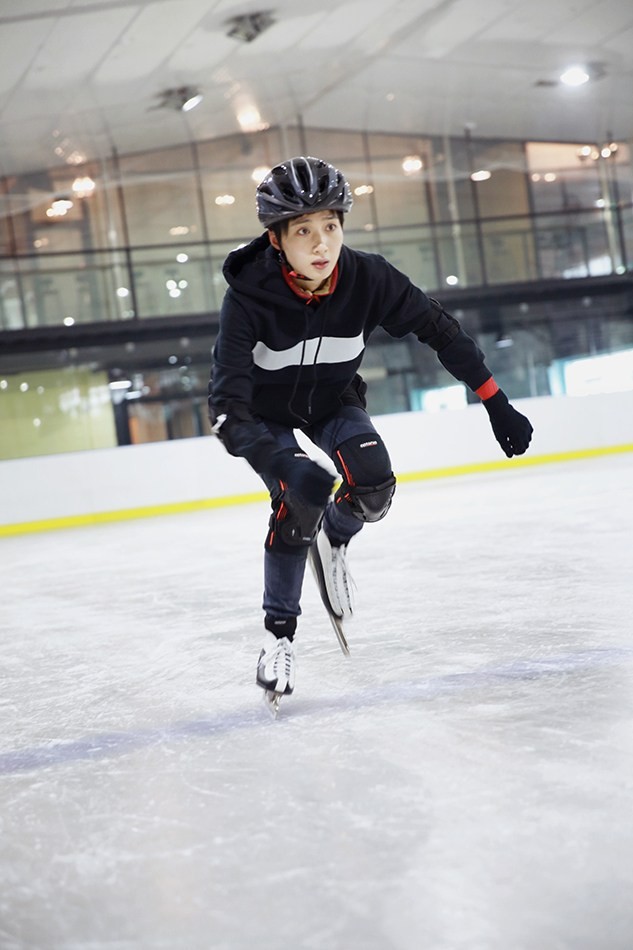 冯文娟屈膝蓄力，如即将离弦之箭般凝视前方冰面