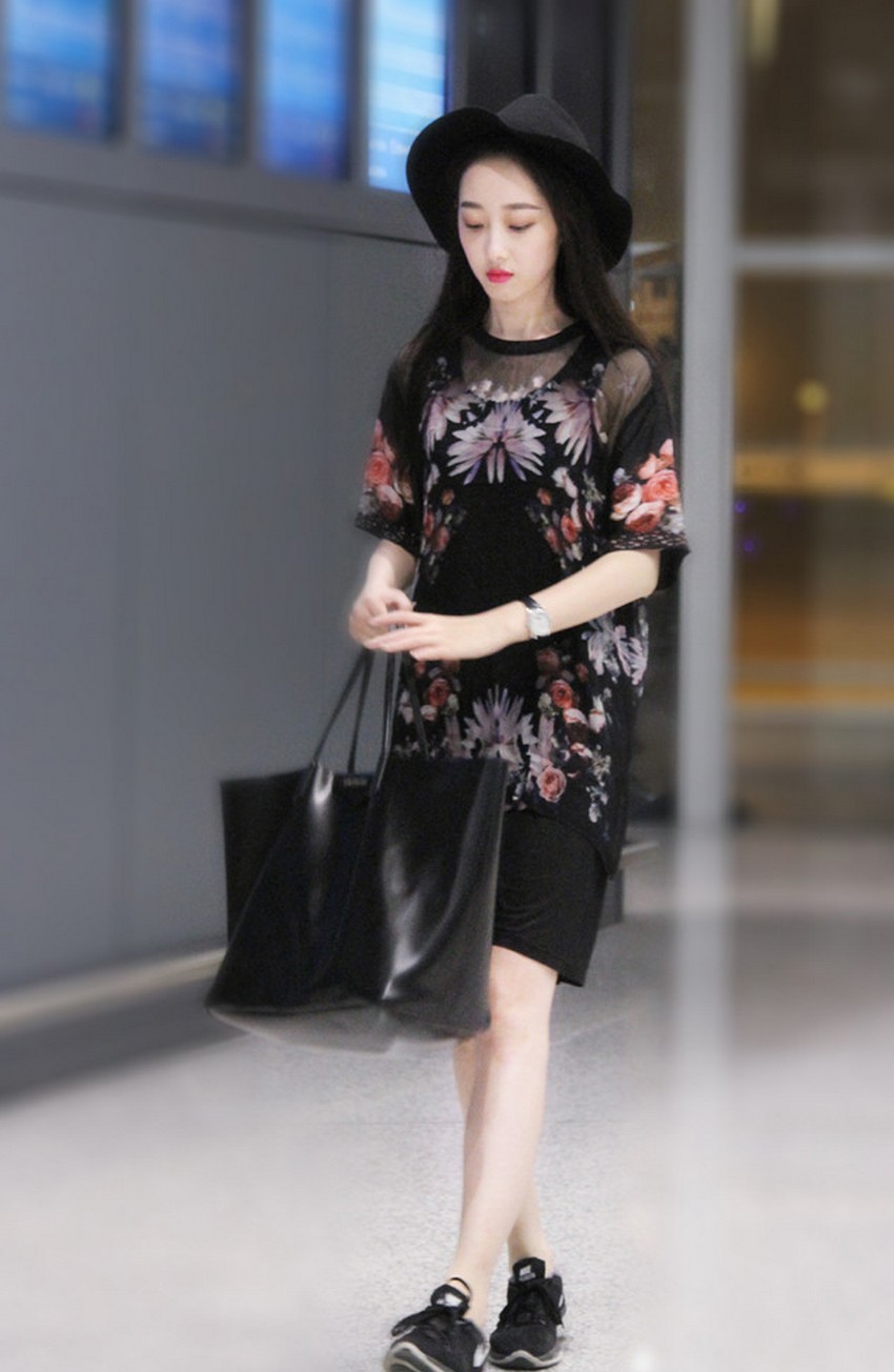 蒋梦婕身着繁花长裙立于都市街头，裙裾飞扬如坠入凡间的花仙子