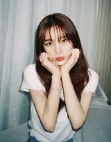 赵樱子盘腿坐在床上俏皮托腮，白T恤牛仔装扮演绎清新少女感