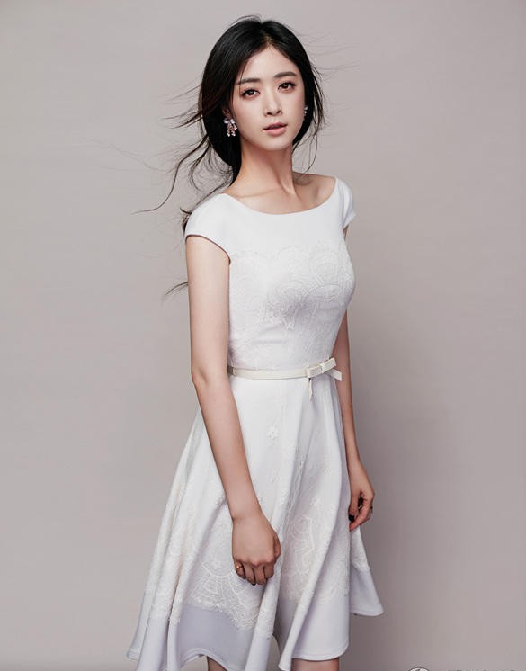 蒋欣身穿一袭浅色修身长裙，侧身回眸，裙摆轻扬，勾勒出优雅纤细的身材曲线