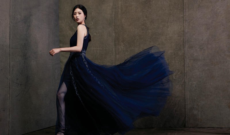 蒋欣倚靠窗边，一袭华美礼服与复古环境相映成趣，神情慵懒而充满故事感