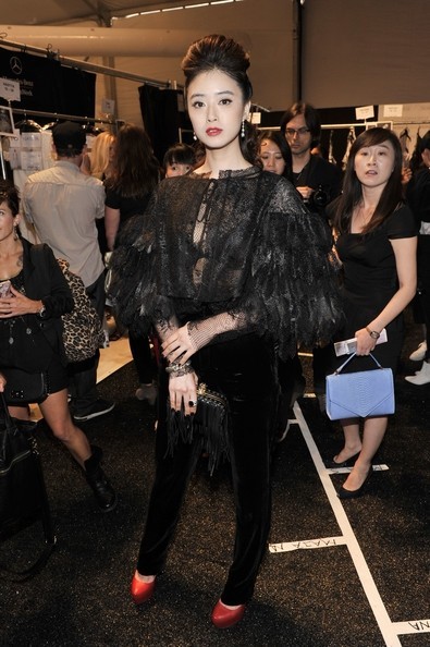 蒋欣一袭黑色蕾丝透视羽毛外套亮相秀场，妆容精致红唇夺目，尽显霸气女王风范