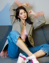 金晨坐于高脚凳上，身体自然舒展，牛仔裤的硬朗与内衣的柔美相得益彰，展现出不刻意讨好、自在从容的时尚态度。