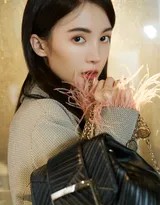 金晨回眸瞬间，表情淡然坚定，室内陈设作为背景衬托，整体构图平衡，突出了她独立而专注的独特气质。