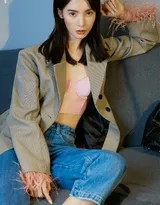 金晨以放松姿态坐在地面，身体自然蜷曲，光影营造出私密而宁静的空间感，展现了其柔美与坚韧并存的另一面。