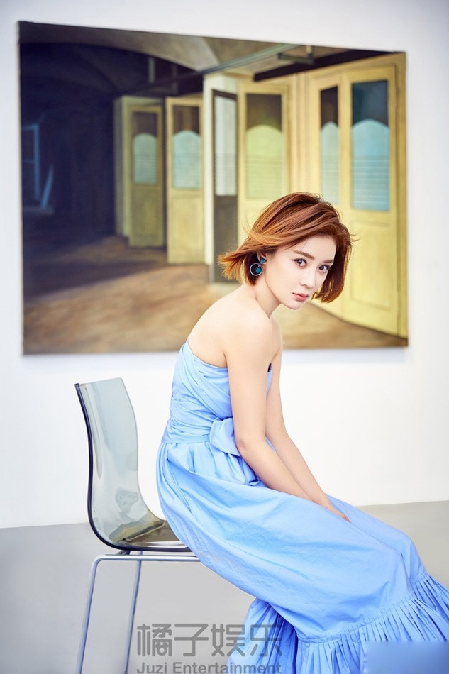 袁姗姗身着天蓝色抹胸长裙侧身回眸，锁骨精致如蝶翼，裙摆如海浪般铺展