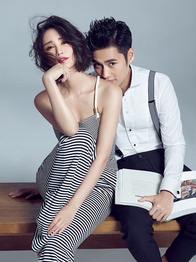 夫妻二人身穿简约时尚服装，在街头背景下默契摆拍，笑容灿烂