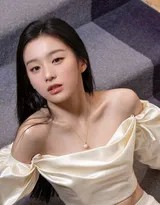 包上恩侧坐于楼梯台阶上，白色长裙如瀑布倾泻，她低头浅笑，尽显温柔娴静之态