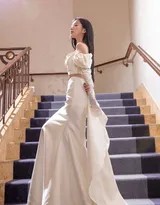 包上恩在楼梯转角处侧身而立，抹胸长裙勾勒出窈窕曲线，她手持花束，浪漫气息弥漫