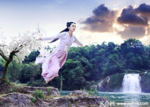 花千骨身着一袭飘逸粉色长裙，手持法器，于朦胧光影中翩然转身，裙摆摇曳如绽放花朵