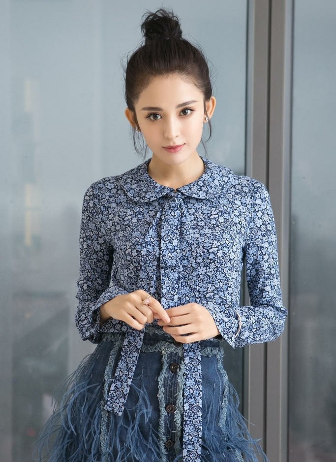 置身简约背景前单手轻撩发丝，展现慵懒随性的日常氛围