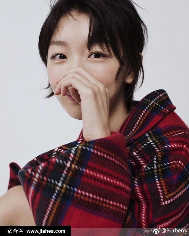 暖阳透过树梢，周冬雨裹紧大衣展露浅笑，冬日暖意扑面而来