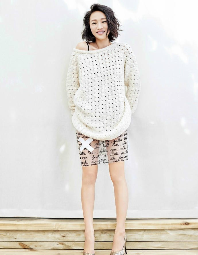 周迅侧身倚靠树干，光线柔和勾勒其面部轮廓，眼神沉静望向林间深处，仿佛与森林私语