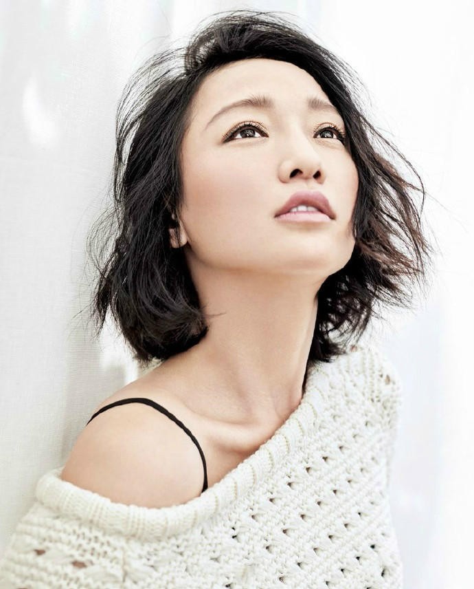 周迅背对镜头走向森林光影深处，宽松衣衫随风微拂，构成一幅充满故事性与探索感的背影画卷