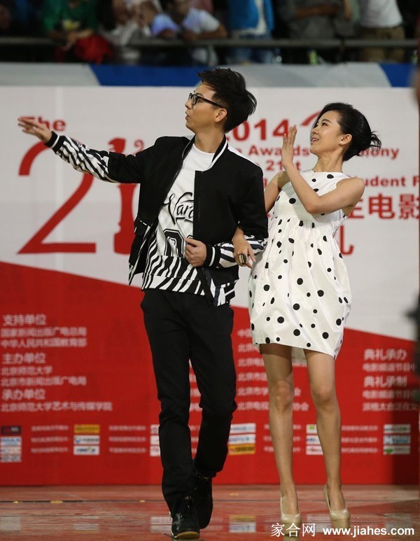 郁可唯坐于高脚凳上，短裙下修长双腿交叠，眼神望向远方，姿态慵懒而迷人