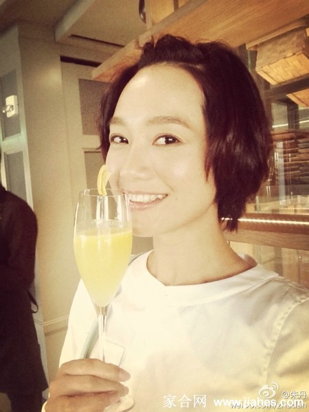 朱丹回老家素颜下田，穿着水靴蹲在菜地边，笑容灿烂而亲切地摘着新鲜蔬菜