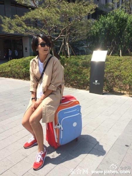 朱丹身穿深色深V上衣，妆容精致，在时尚光影中展现锁骨线条与成熟知性魅力