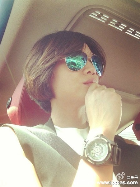 朱丹冬日户外写真，身着温暖毛衣凝视远方，自然光线衬托出其宁静柔和的侧脸