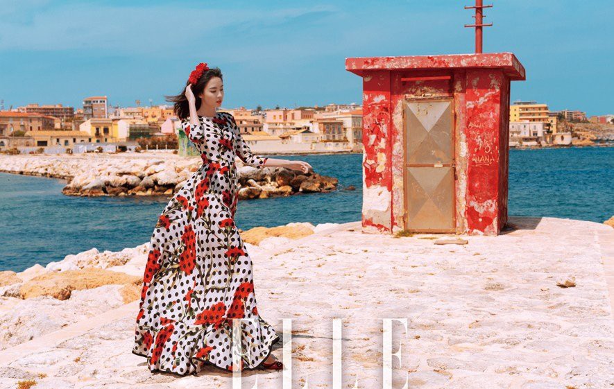 张梓琳坐在鲜花点缀的露台，手持咖啡杯展露惬意微笑，演绎意式甜蜜午后时光