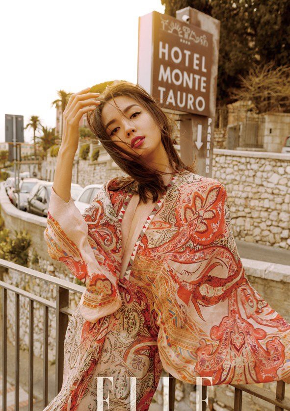 逆光中她轻抚发丝，轮廓泛起金色光晕，宛如从古典油画中走出的优雅女神