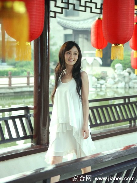 姚笛漫步林荫下，格纹套装与黑色背心衬出随性洒脱的时尚态度