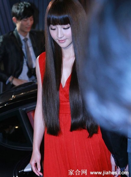 光影交错间，姚笛展露优雅微笑，裙摆摇曳如绽放的花朵