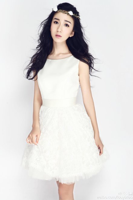 娄艺潇手轻抚面颊置身柔和光晕中，宛若梦境里的白衣仙子翩然而立