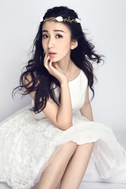 娄艺潇回眸瞬间被抓拍，光影勾勒出优雅侧颜，白色裙裾随风轻扬