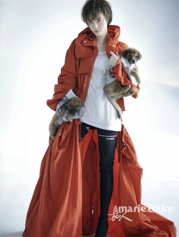 孙俪穿着家居风格的针织衫，笑容灿烂地举起一只可爱的小狗，充满活泼的动感与喜悦