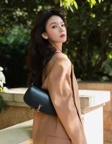 午后阳光穿过，陈瑶坐在木质长凳上翻看杂志，脚边购物袋平添生活气息，画面温馨如日常一隅