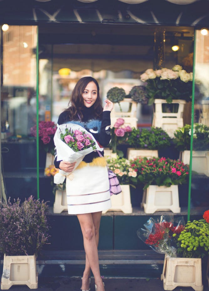 张嘉倪一袭卡其衬衫与灰色长裙倚墙而立，静谧中散发温柔力量