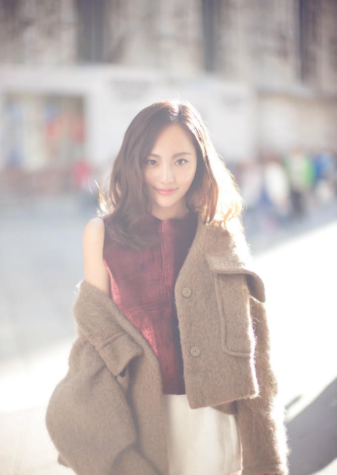 张嘉倪凝望远处，建筑穹顶与柔和光线衬托其沉静优雅氛围