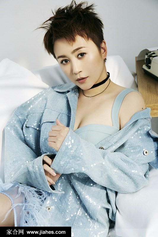 马丽倚靠墙边，光影交错中牛仔衬衫与复古颈链的细节被放大，展现出不羁与优雅并存的独特气质