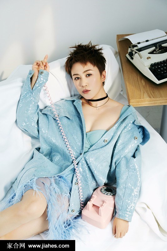 马丽身着深色牛仔外套侧身回眸，利落短发下黑色复古颈链若隐若现，眼神中透露出自信与洒脱