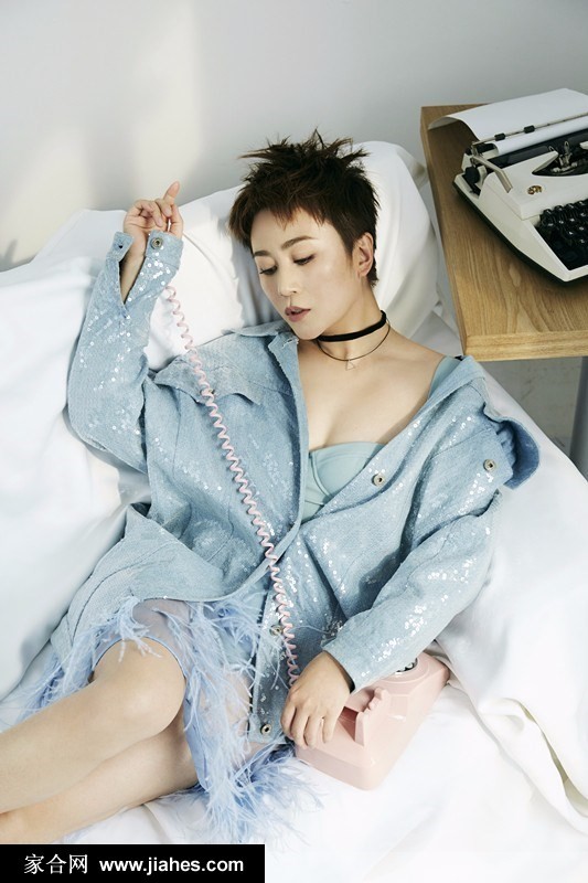 马丽身着全套牛仔装束漫步于都市街景，短发随风轻扬，颈间复古配饰在自然光线下闪烁着低调光泽