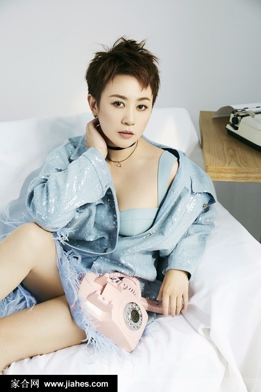 马丽置身于简约背景前，牛仔衬衫解开领口，搭配复古颈链，展现随性不羁而又充满高级感的时尚品味