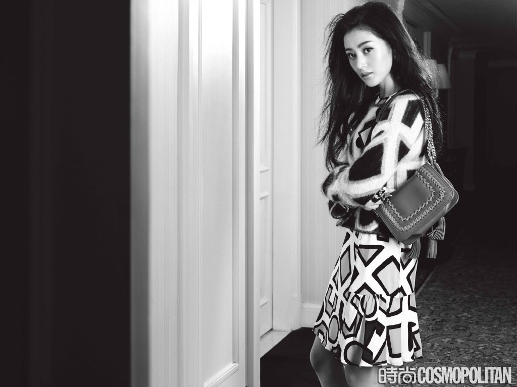 张天爱以慵懒神秘姿态倚坐，额间碎发与深邃目光交织，流露出冷艳而高级的成熟诱惑