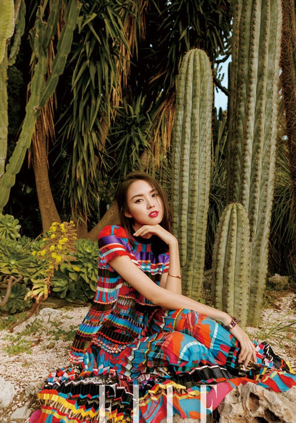 张梓琳身着深色长裙立于黄昏光影中裙身印花与身后古老建筑纹理呼应