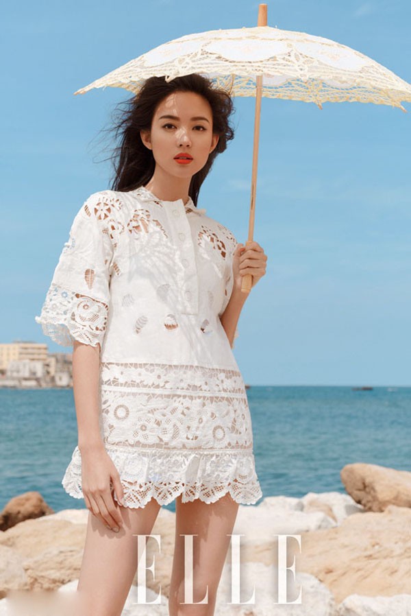 张梓琳在海边礁石上张开双臂迎接海风长裙与发丝一同随风飘扬