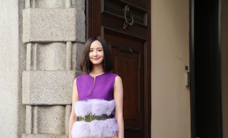 张歆艺身着酒红色棒球衫与报纸印花卫衣，在秋日阳光下绽放明媚笑容