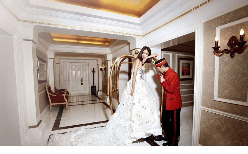 张歆艺优雅侧坐，婚纱裙摆如花朵般铺陈绽放