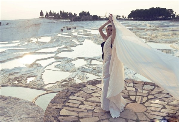 戚薇手持白纱一角翩然转身，裙裾旋开如绽放白莲，动态瞬间凝固成永恒